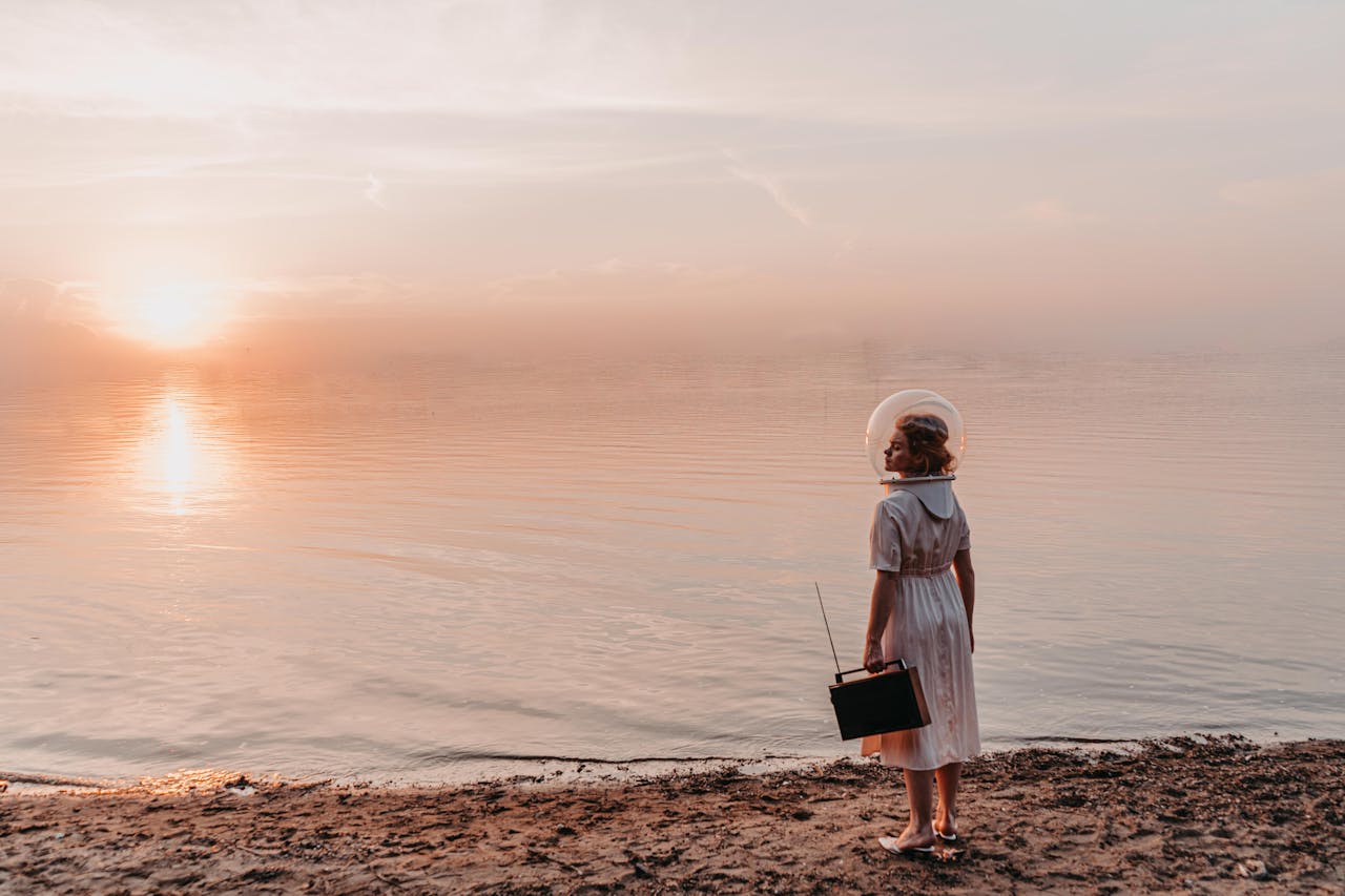 Woman in Astronaut Helmet Standing on Beach